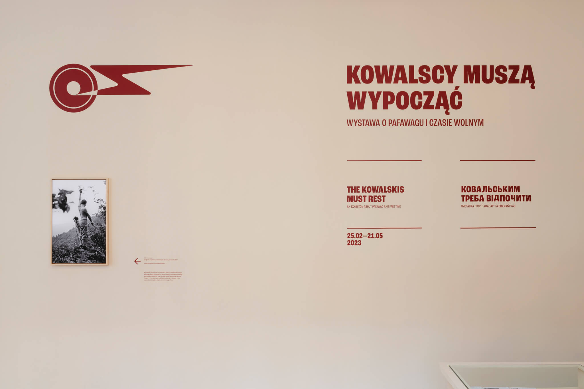 dokumentacja wystawy, czerwony napis z tytułem na beżowej ścianie