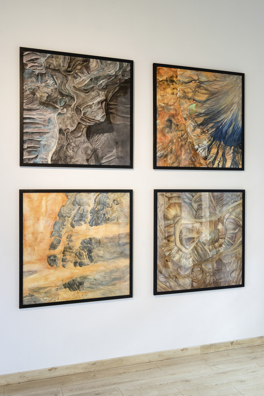 Cztery obrazy, kwadratowe, wiszące na ścianie. Każdy z nich przedstawia zbliżenie z satelity NASA na detale widoku Ziemi oraz Marsa, dość abstrakcyjne