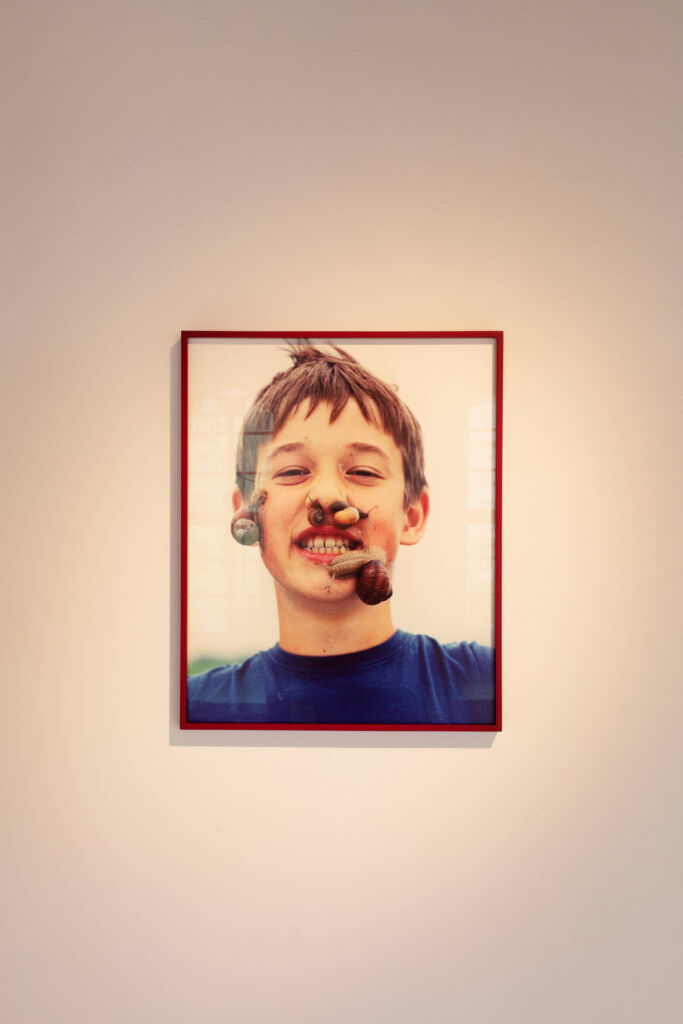 A photo of a boy with his mouth open on a wall.