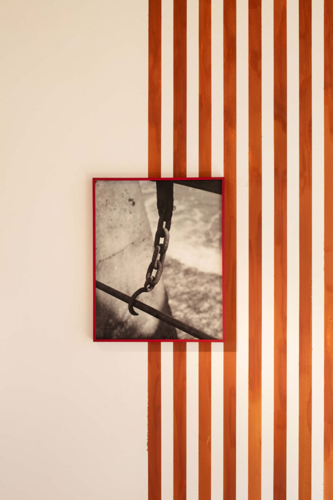 An orange and white striped wall with a photo hanging on it.