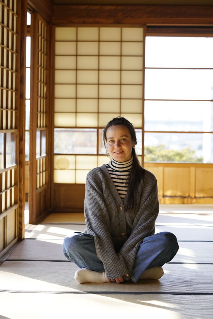 A woman sitting on the floor in a japanese room.