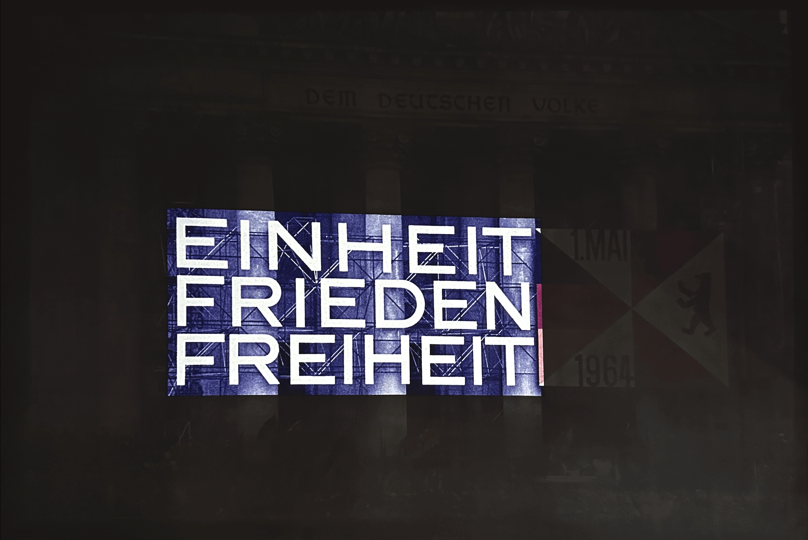 Projekcja niemieckich słów „einheit, frieden, freiheit” oznaczających „jedność, pokój, wolność” na fasadzie budynku.