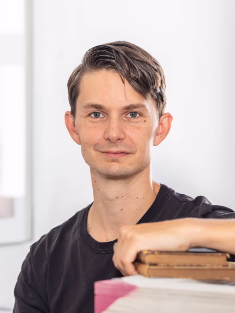 Mężczyzna trzymający stos książek.